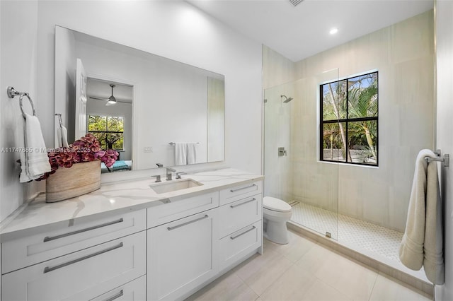 bathroom with tile patterned flooring, vanity, an enclosed shower, and toilet