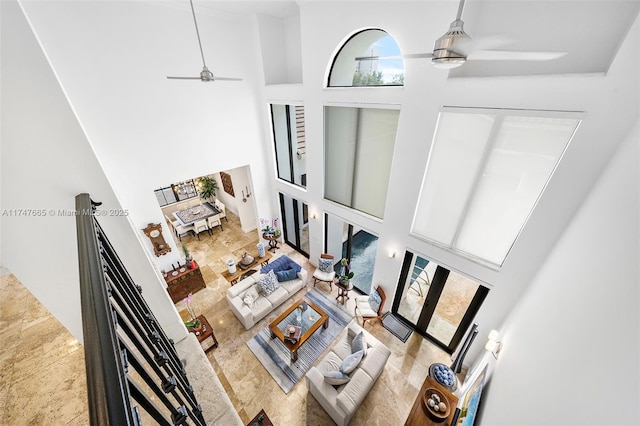 living room with ceiling fan and a high ceiling