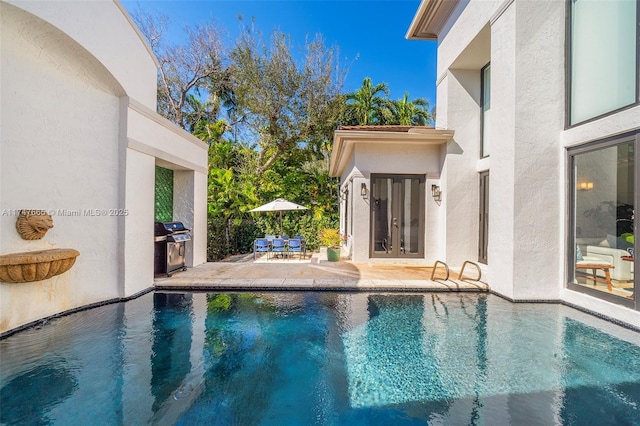 view of pool with a grill and a patio area