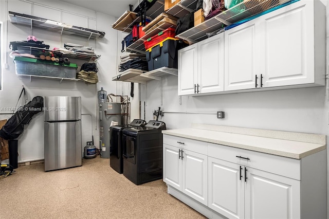 kitchen featuring electric water heater, white cabinets, washer and clothes dryer, and stainless steel fridge