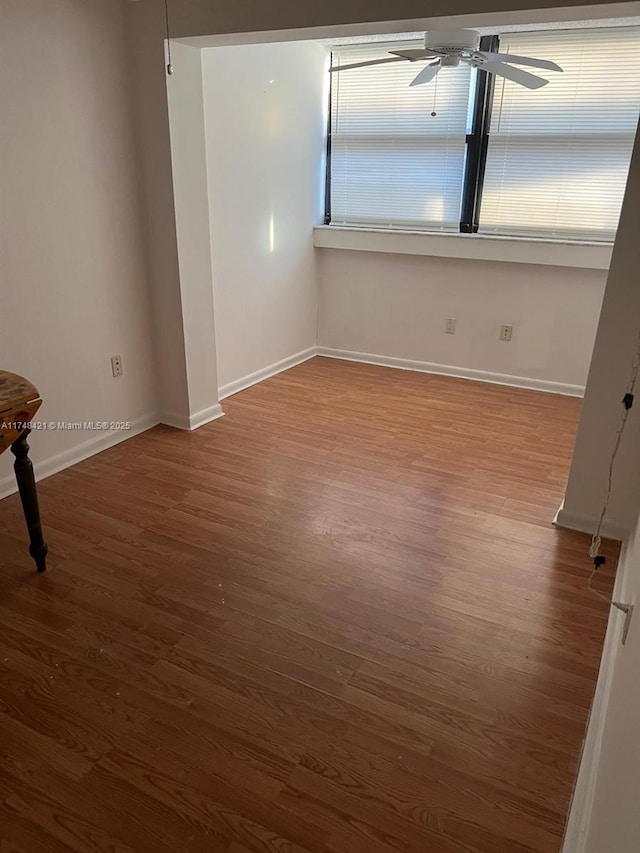 spare room with ceiling fan, wood finished floors, and baseboards