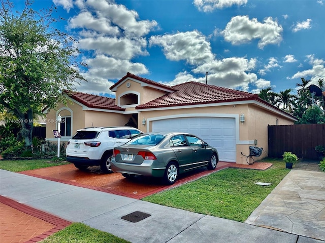 view of front of home featuring stucco siding, an attached garage, fence, a tiled roof, and a front lawn