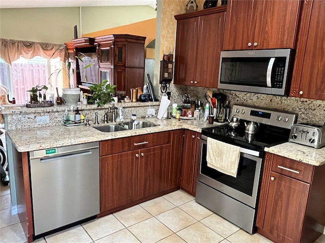 kitchen with light tile patterned flooring, stainless steel appliances, tasteful backsplash, lofted ceiling, and a sink