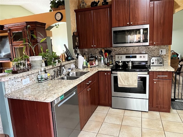 kitchen featuring light tile patterned floors, tasteful backsplash, a sink, and stainless steel appliances