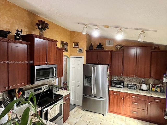 kitchen featuring light stone countertops, appliances with stainless steel finishes, light tile patterned floors, visible vents, and decorative backsplash