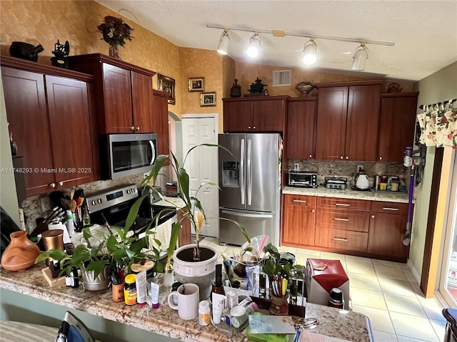 kitchen with light tile patterned flooring, backsplash, stainless steel appliances, a toaster, and visible vents