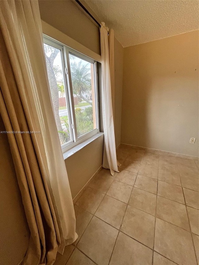 interior space with a textured ceiling and tile patterned floors