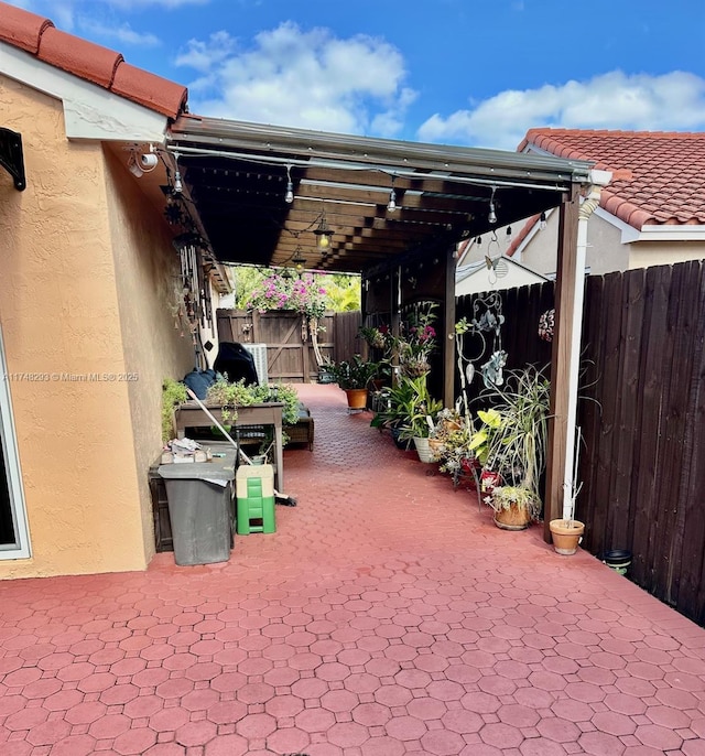 view of patio with a pergola and fence