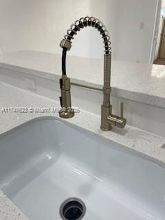 interior details with sink and light stone countertops