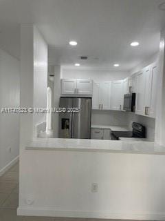 kitchen featuring white cabinetry, black appliances, and kitchen peninsula