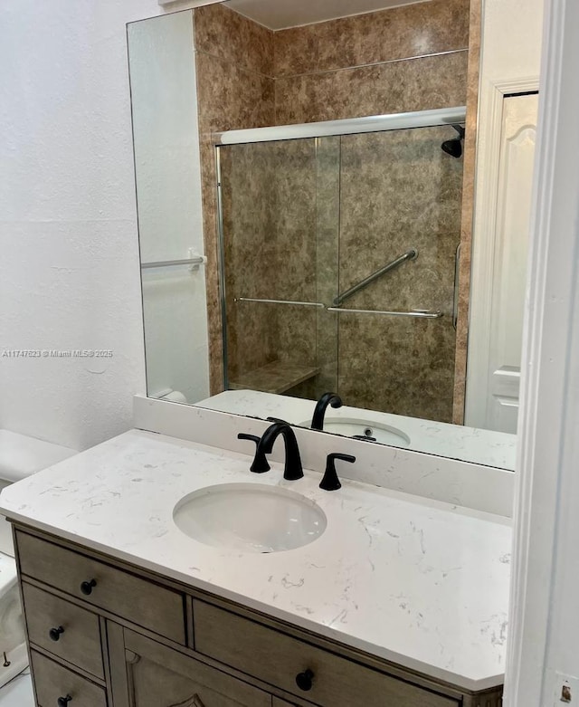 bathroom with toilet, vanity, and walk in shower