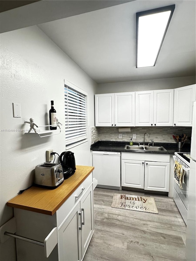 kitchen featuring sink, white appliances, and white cabinetry