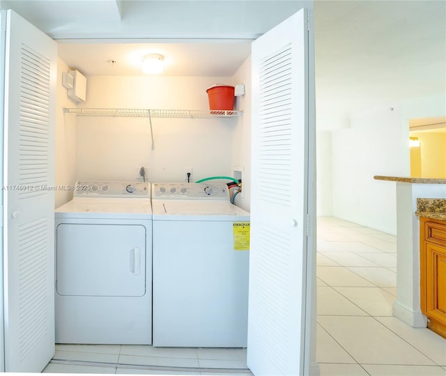 laundry room featuring light tile patterned floors, washing machine and dryer, and laundry area
