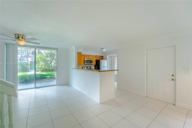 kitchen with a kitchen breakfast bar, stainless steel appliances, ceiling fan, light tile patterned floors, and kitchen peninsula