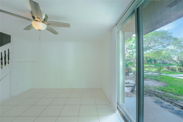 tiled spare room with ceiling fan