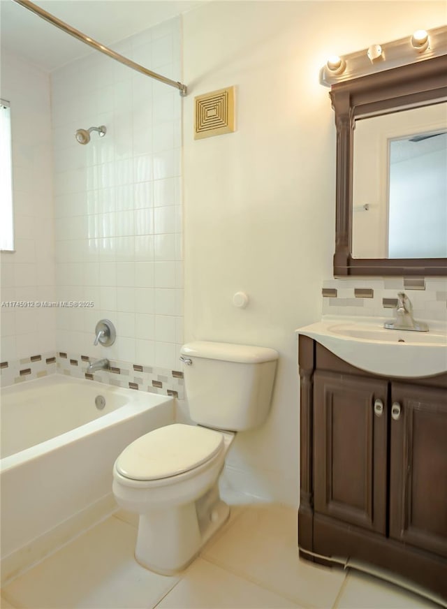 bathroom featuring tasteful backsplash, toilet, tub / shower combination, vanity, and tile patterned floors