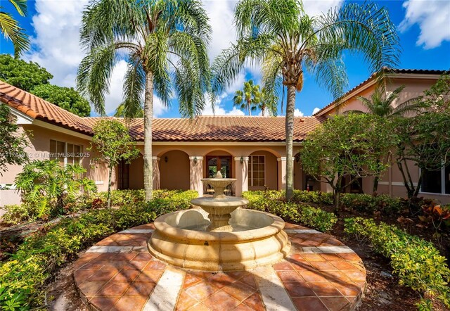mediterranean / spanish house featuring stucco siding and a tiled roof