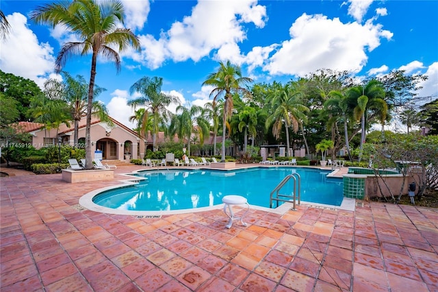 view of swimming pool with a patio area and a hot tub