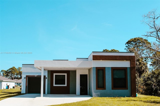 contemporary home featuring a front lawn and a garage