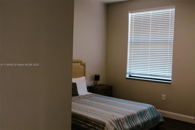 bedroom with dark hardwood / wood-style flooring