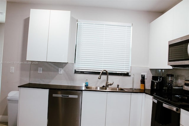 kitchen with sink, backsplash, white cabinetry, and stainless steel appliances