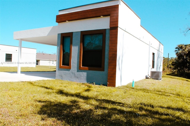 view of home's exterior featuring a yard and central AC