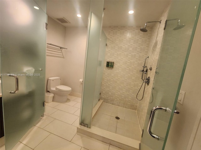 bathroom featuring tile patterned floors, toilet, and an enclosed shower