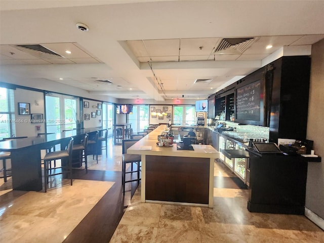 interior space featuring a paneled ceiling, french doors, a breakfast bar, and kitchen peninsula