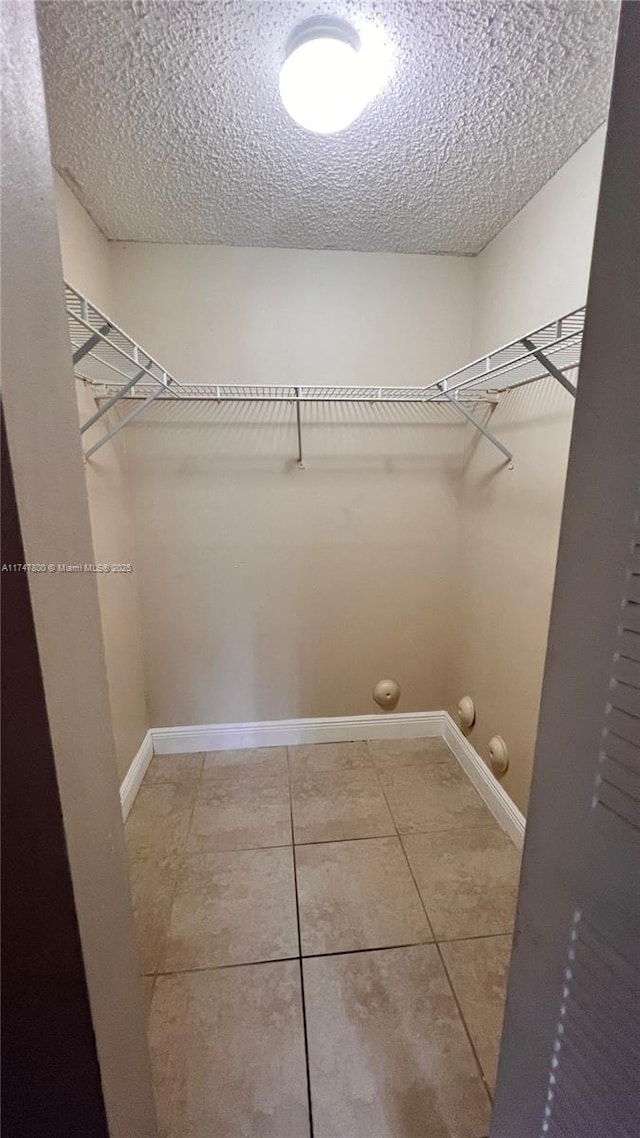 walk in closet with tile patterned floors