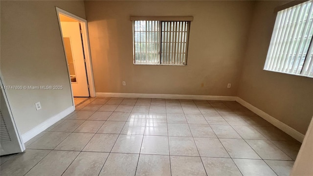 unfurnished room featuring plenty of natural light, baseboards, and light tile patterned floors