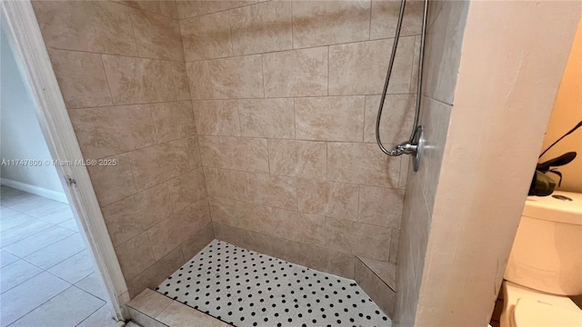 bathroom featuring a tile shower and toilet