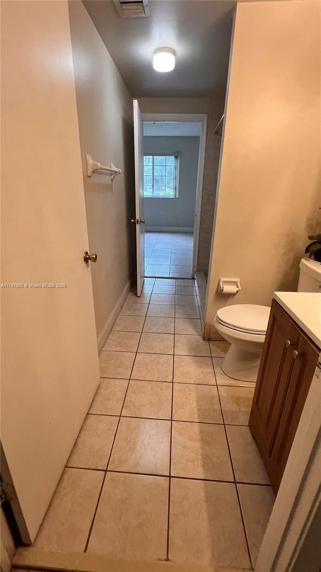 full bath with vanity, walk in shower, baseboards, toilet, and tile patterned flooring