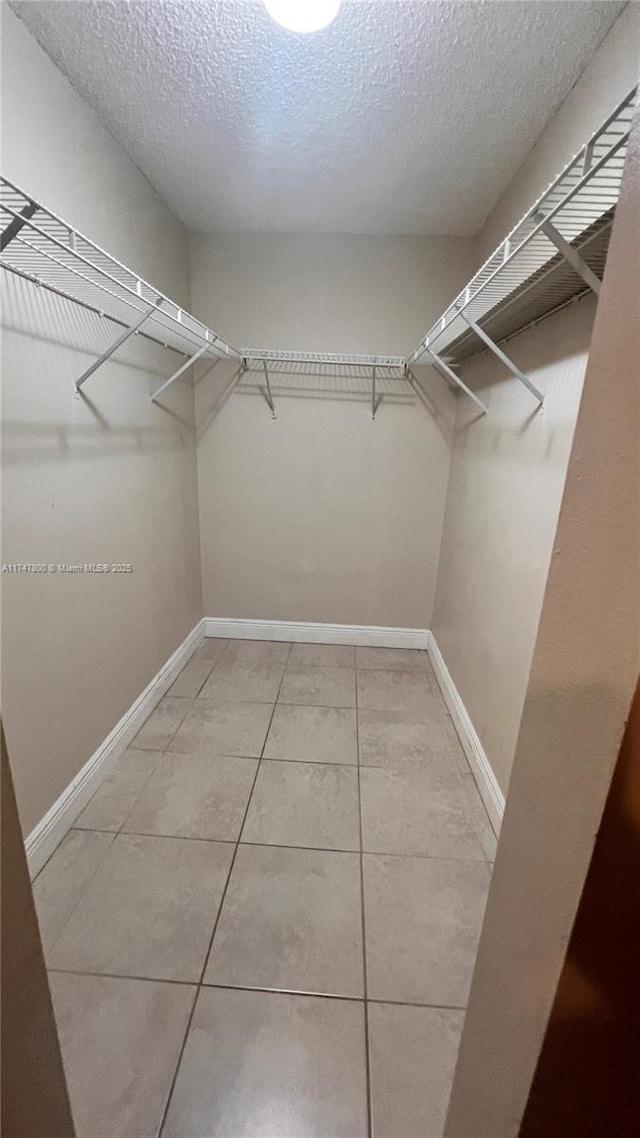 walk in closet with tile patterned floors