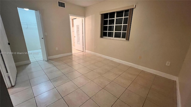 unfurnished bedroom with a spacious closet, visible vents, light tile patterned flooring, a closet, and baseboards