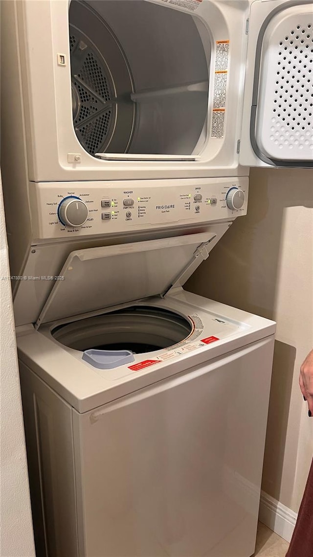 clothes washing area featuring stacked washing maching and dryer