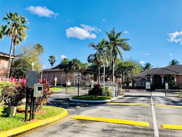 view of road with a gate, a gated entry, and curbs