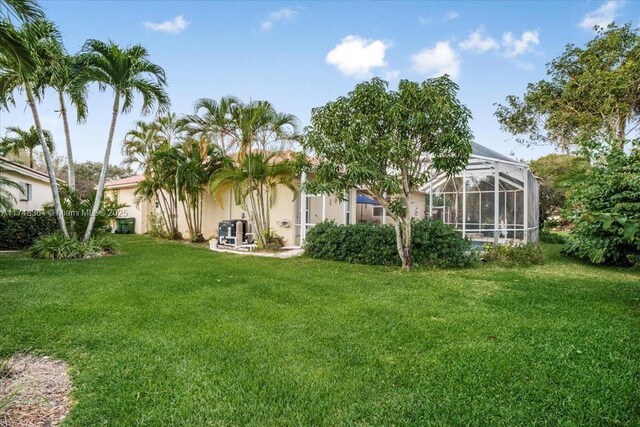 2813 Augusta Ln, Homestead, FL 33035 - back of property with a yard, stucco siding, and glass enclosure