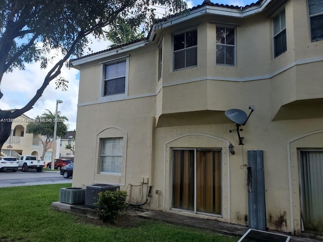 back of property with a yard and cooling unit