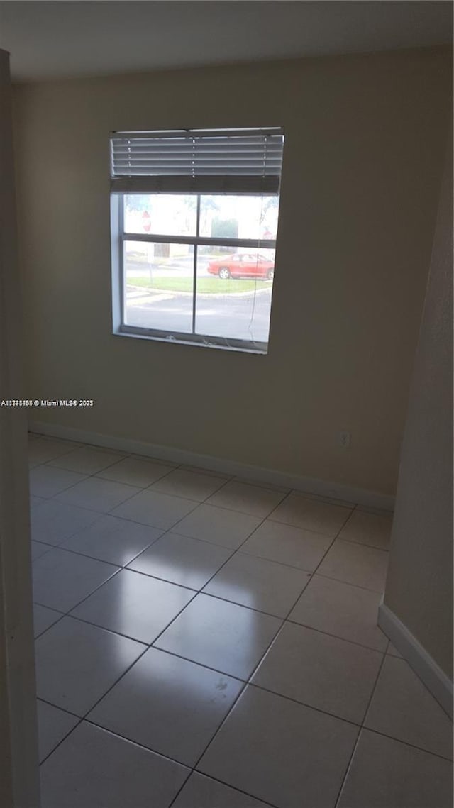 spare room featuring light tile patterned flooring