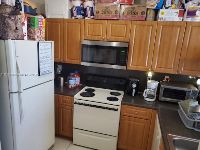 kitchen featuring sink, white appliances, and light tile patterned floors