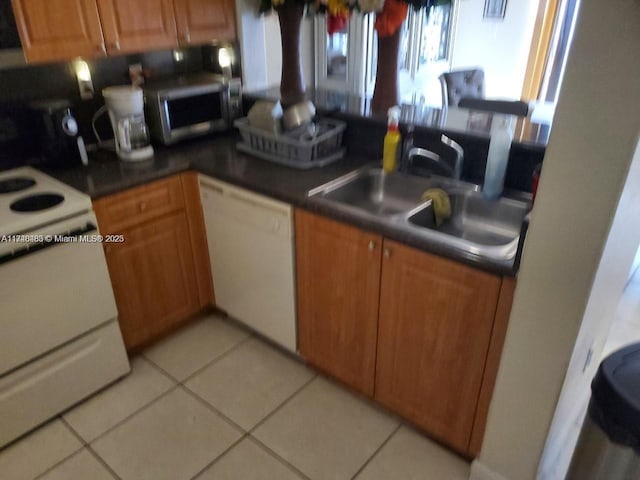 kitchen featuring sink, white appliances, and light tile patterned floors