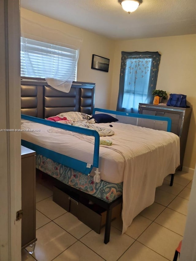 tiled bedroom with a textured ceiling