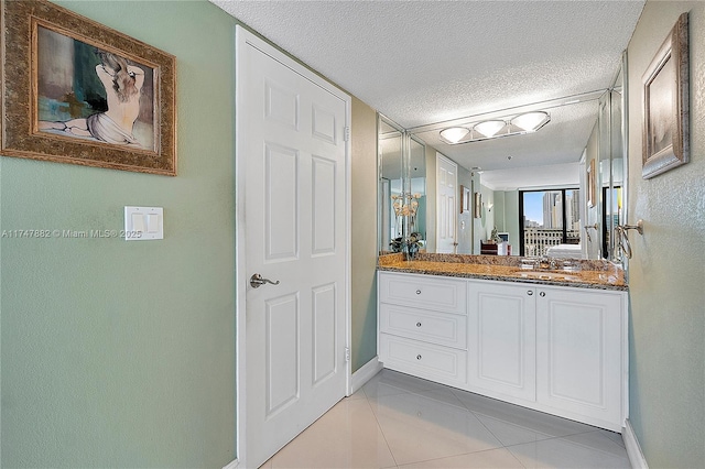 bathroom featuring vanity, a textured ceiling, and tile patterned flooring