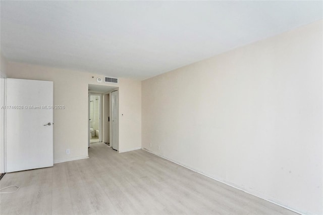 unfurnished room with light wood-type flooring and visible vents