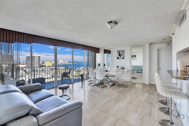 living room with a water view and a textured ceiling