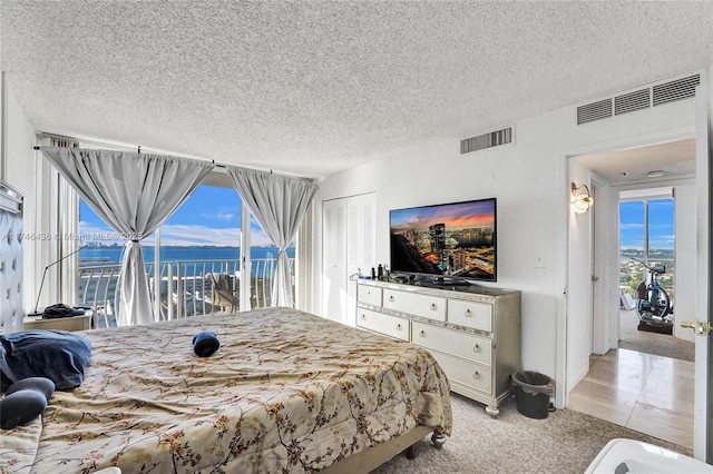 carpeted bedroom featuring a closet, access to exterior, and a textured ceiling