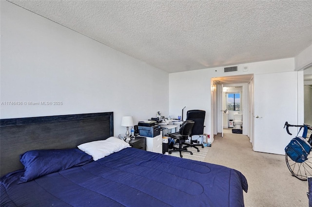 bedroom with a textured ceiling and light colored carpet