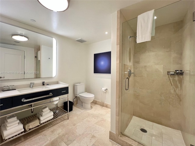 bathroom featuring toilet, vanity, and a shower with shower door