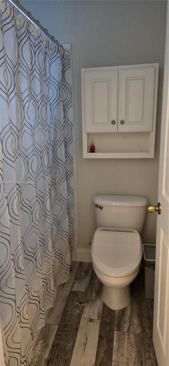 bathroom with wood-type flooring and toilet