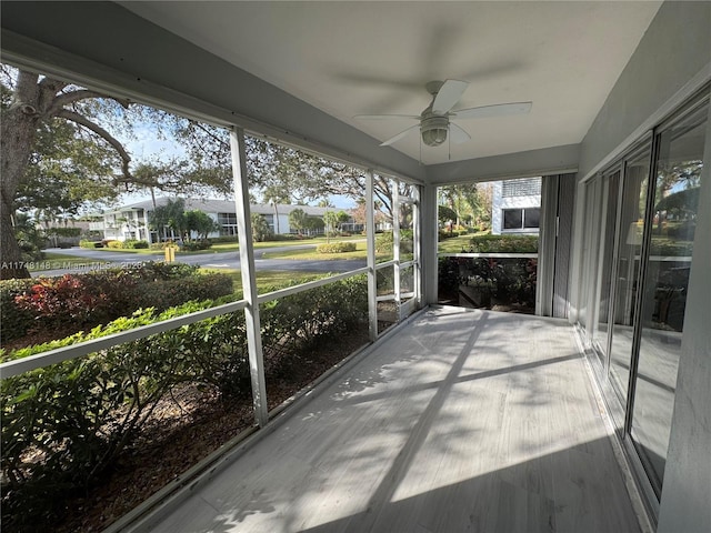 unfurnished sunroom with ceiling fan